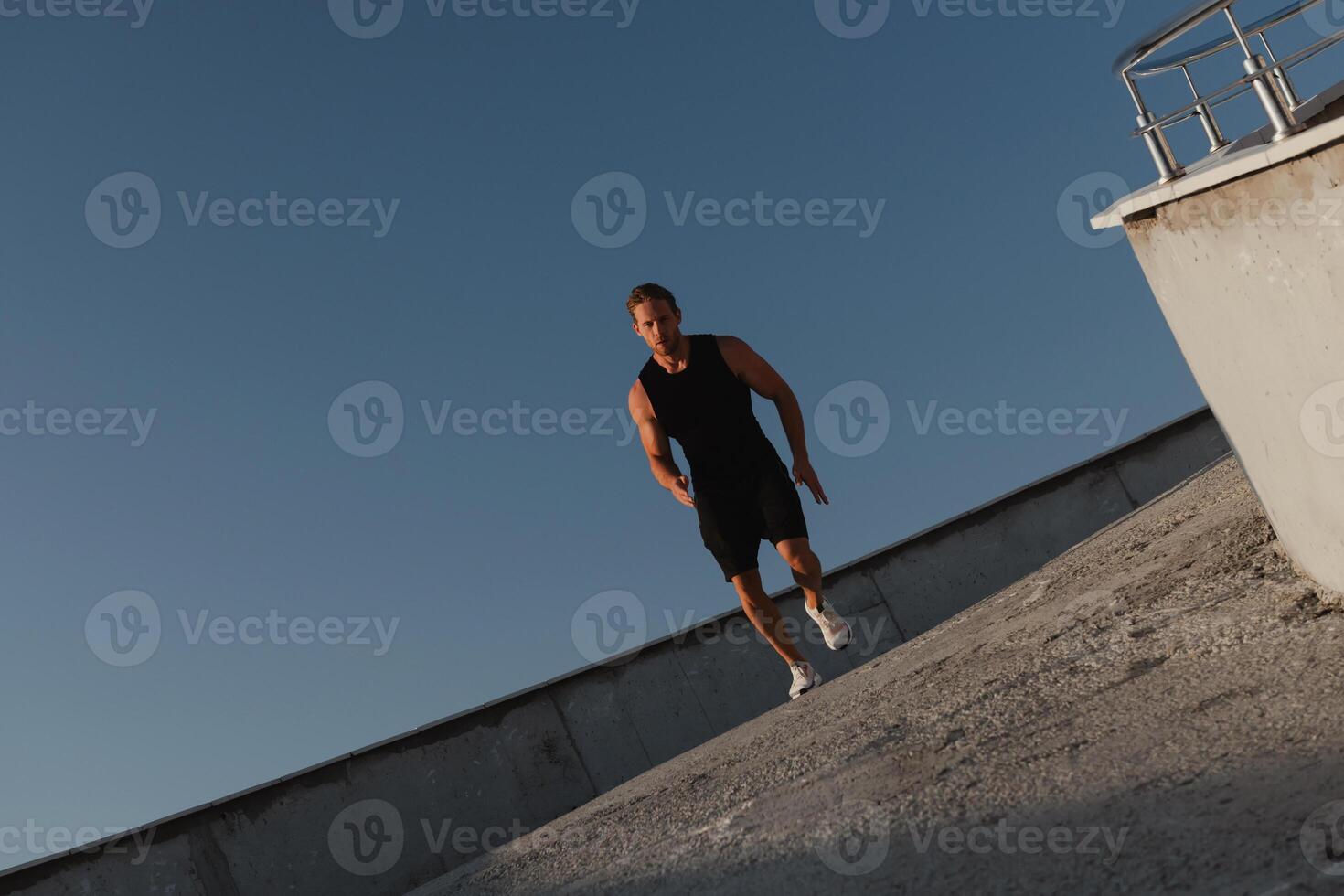 Confident young man in sports clothing enjoying morning jog outdoors photo