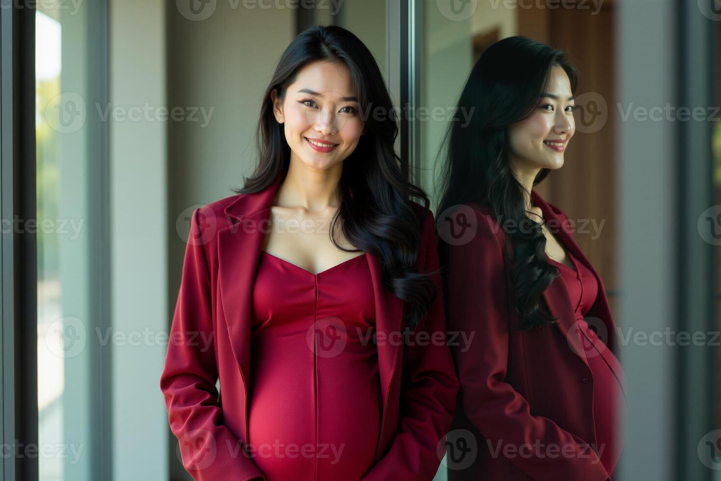 photo of happy pregnant woman standing and posing for picture with mirror and glass wall in background,