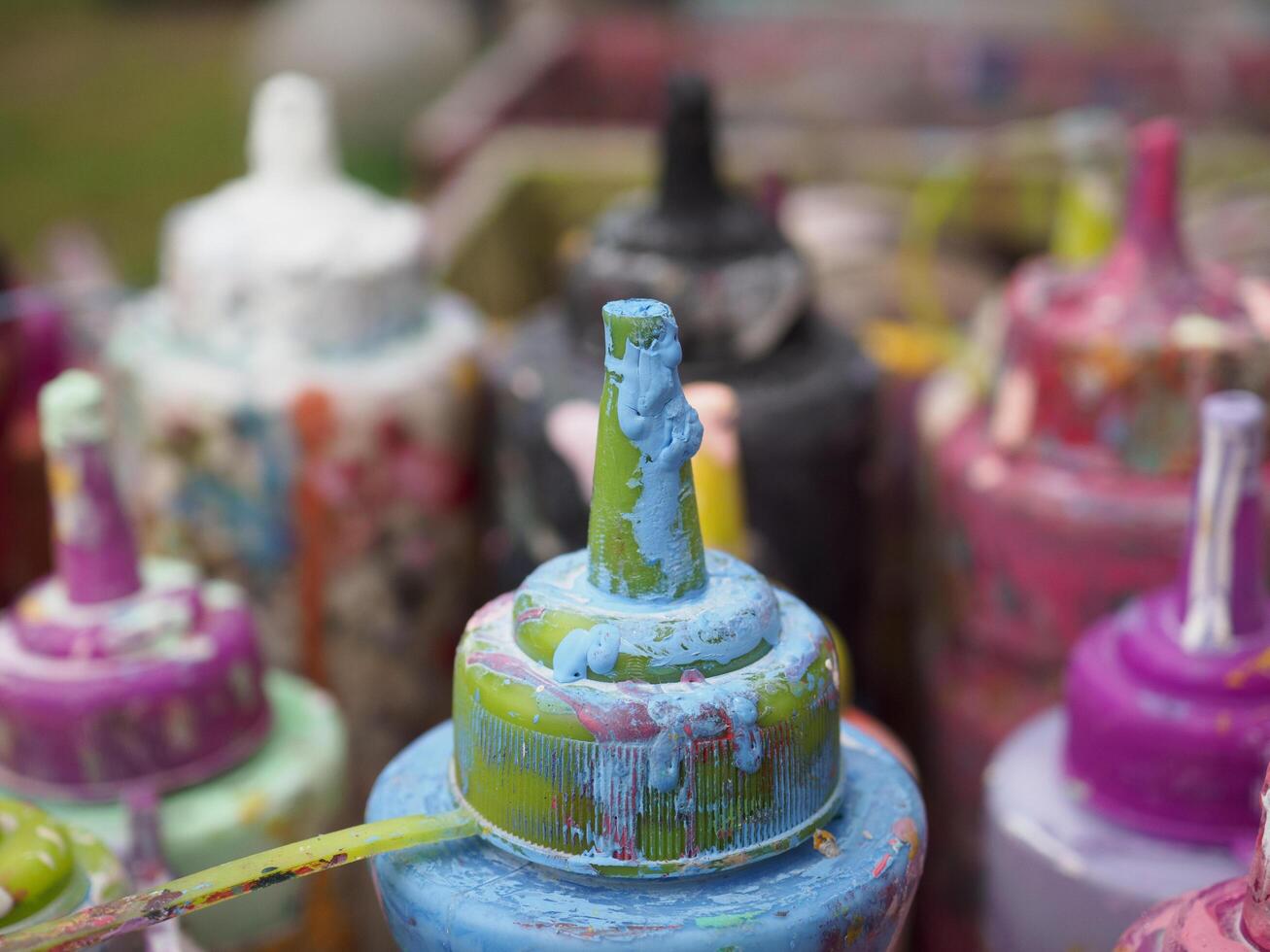 Colorful paint bottles in an old basket photo