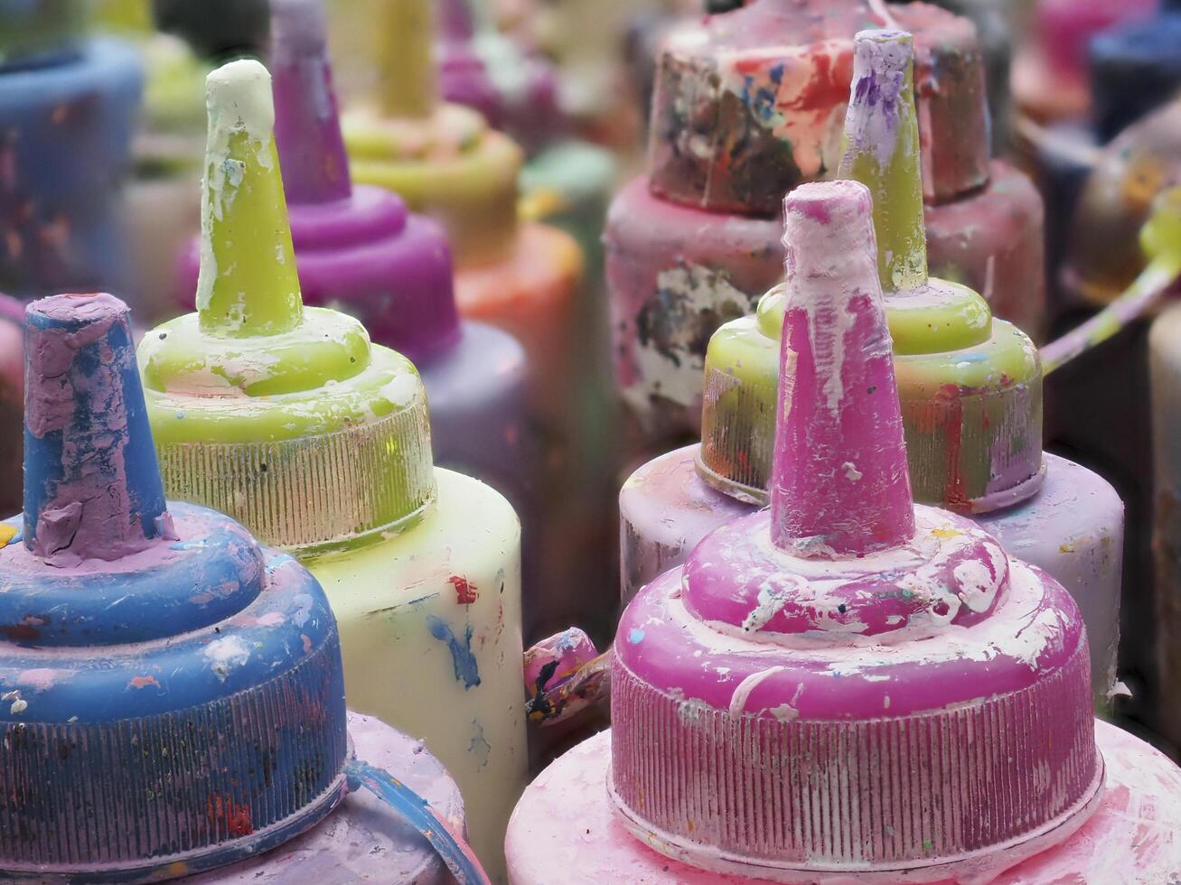 Colorful paint bottles in an old basket photo