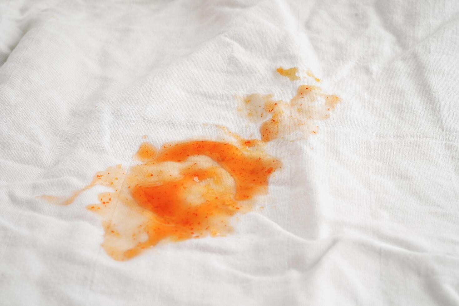 Dirty spicy sauce stain on cloth to wash with washing powder, cleaning housework concept. photo