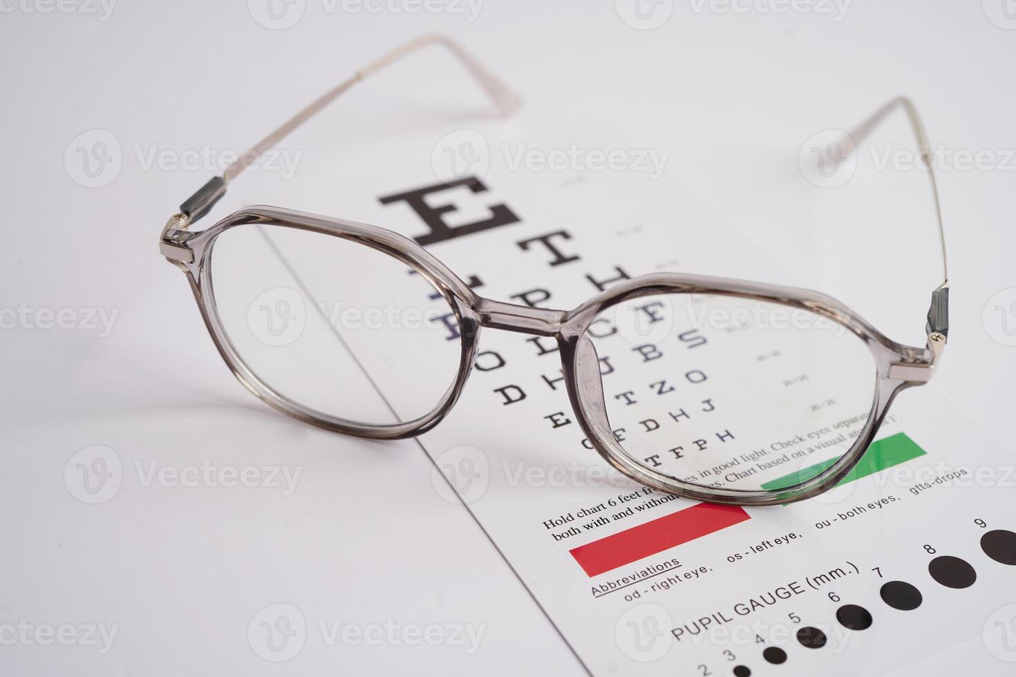 Glasses on eye exam chart to test eyesight accuracy of reading. photo