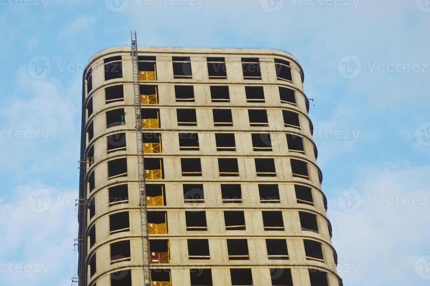 A multi-storey residential building under construction against the blue sky. A fragment of the facade of modern urban architecture. photo