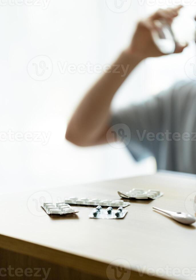 man takes medicine, patient drinks pills, blisters with pills on the table, medicine concept photo