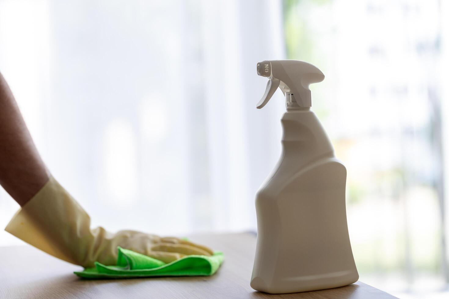 man in yellow protective gloves dusting with cleaning agent. cleaning in apartment photo
