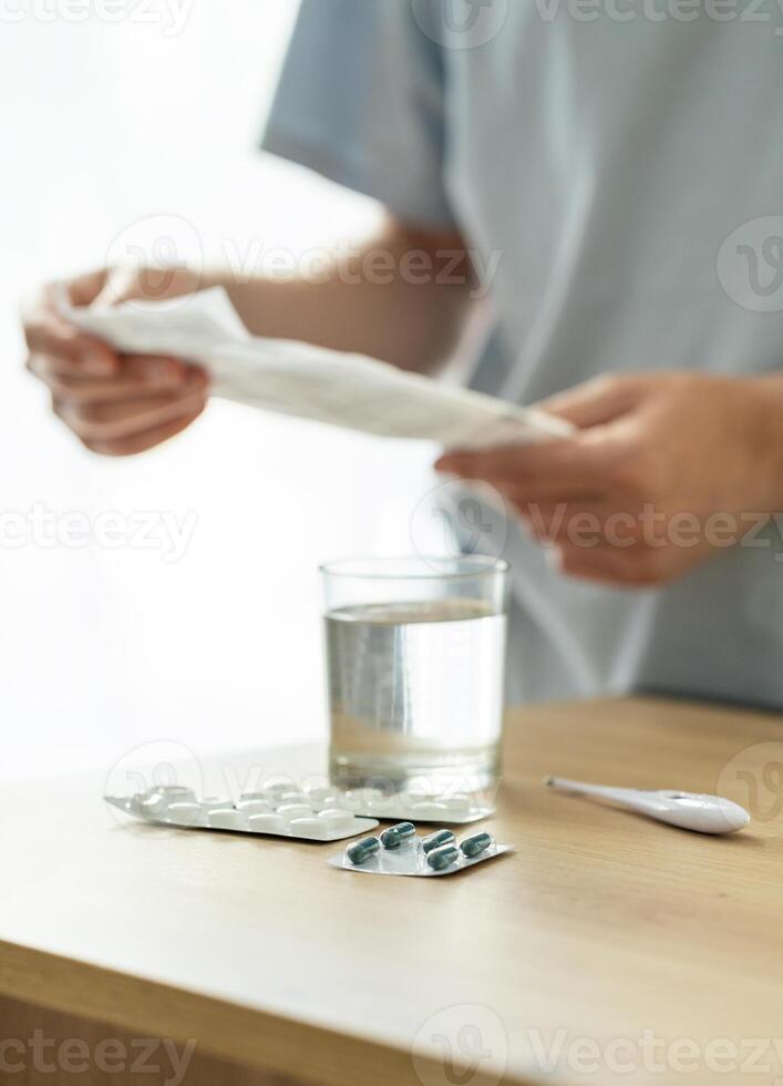 man takes medicine, patient drinks pills, blisters with pills on the table, medicine concept photo