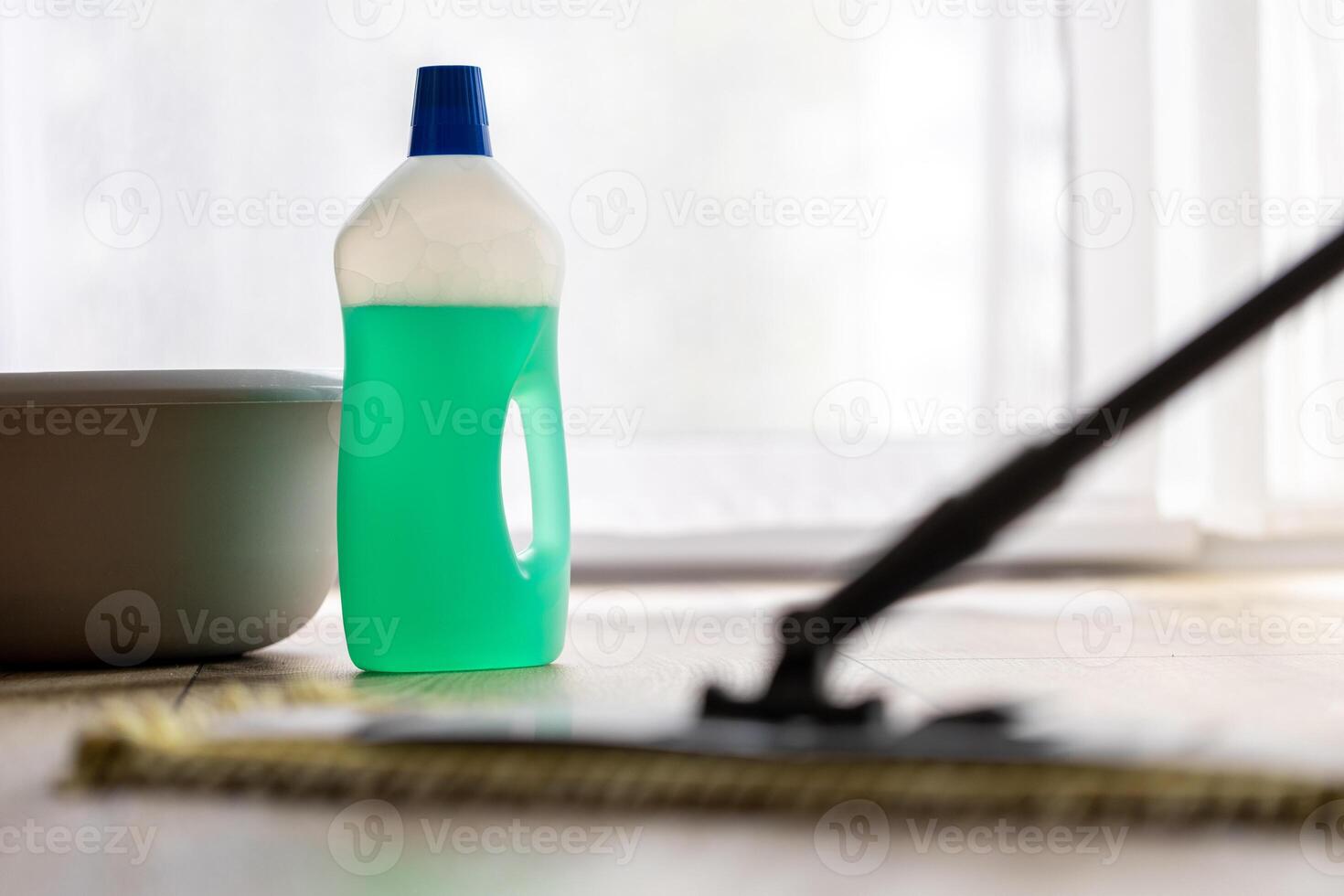 cleaning a wooden floor with a mop, cleaning agent bottle photo