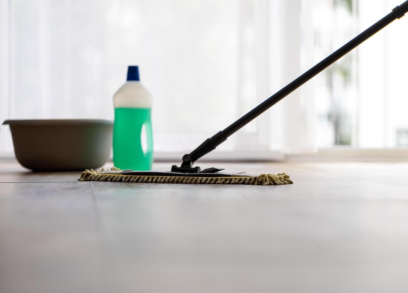 cleaning a wooden floor with a mop, cleaning agent bottle photo