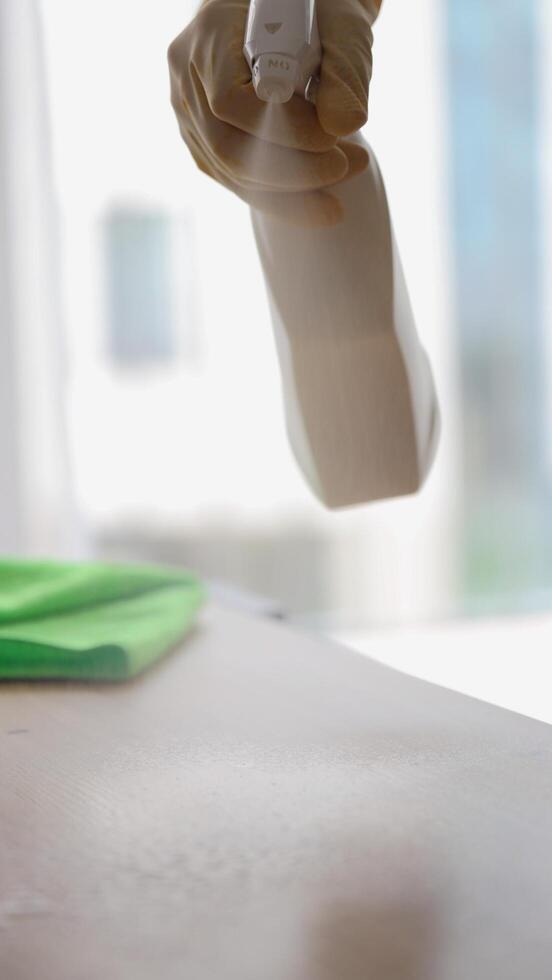 man in yellow protective gloves dusting with cleaning agent. cleaning in apartment photo