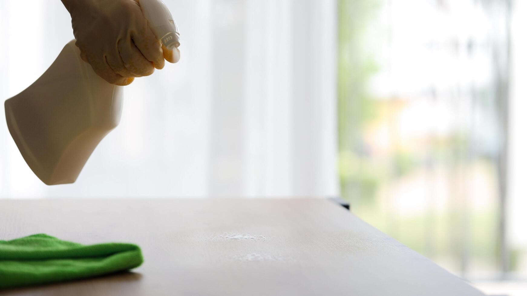 man in yellow protective gloves dusting with cleaning agent. cleaning in apartment photo