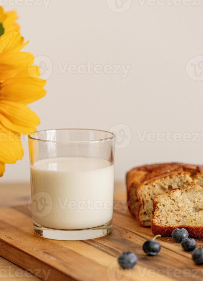 glass of milk and sweet homemade banana bread with crispy crust on a wooden board, dessert photo