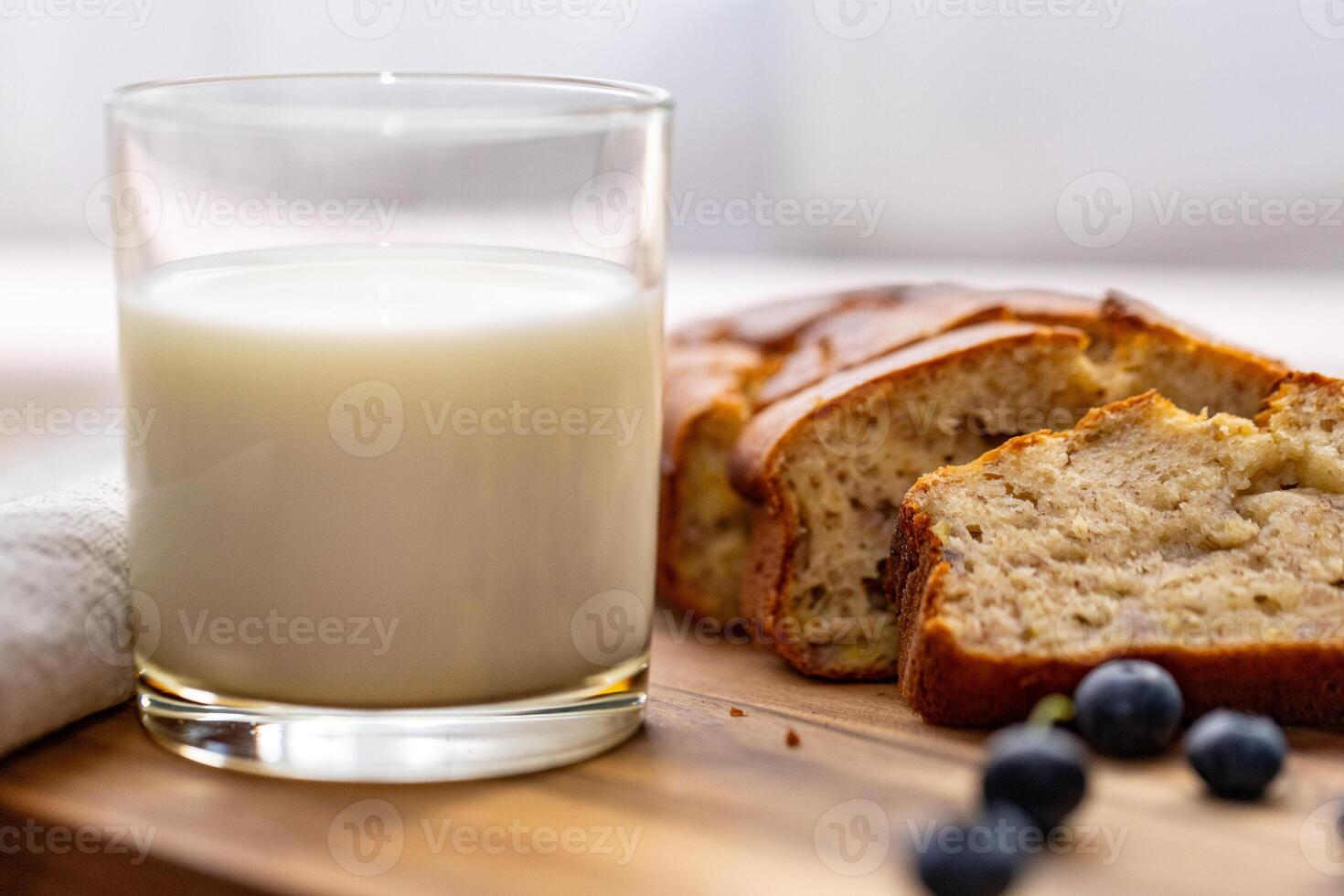 glass of milk and sweet homemade banana bread with crispy crust on a wooden board, dessert photo