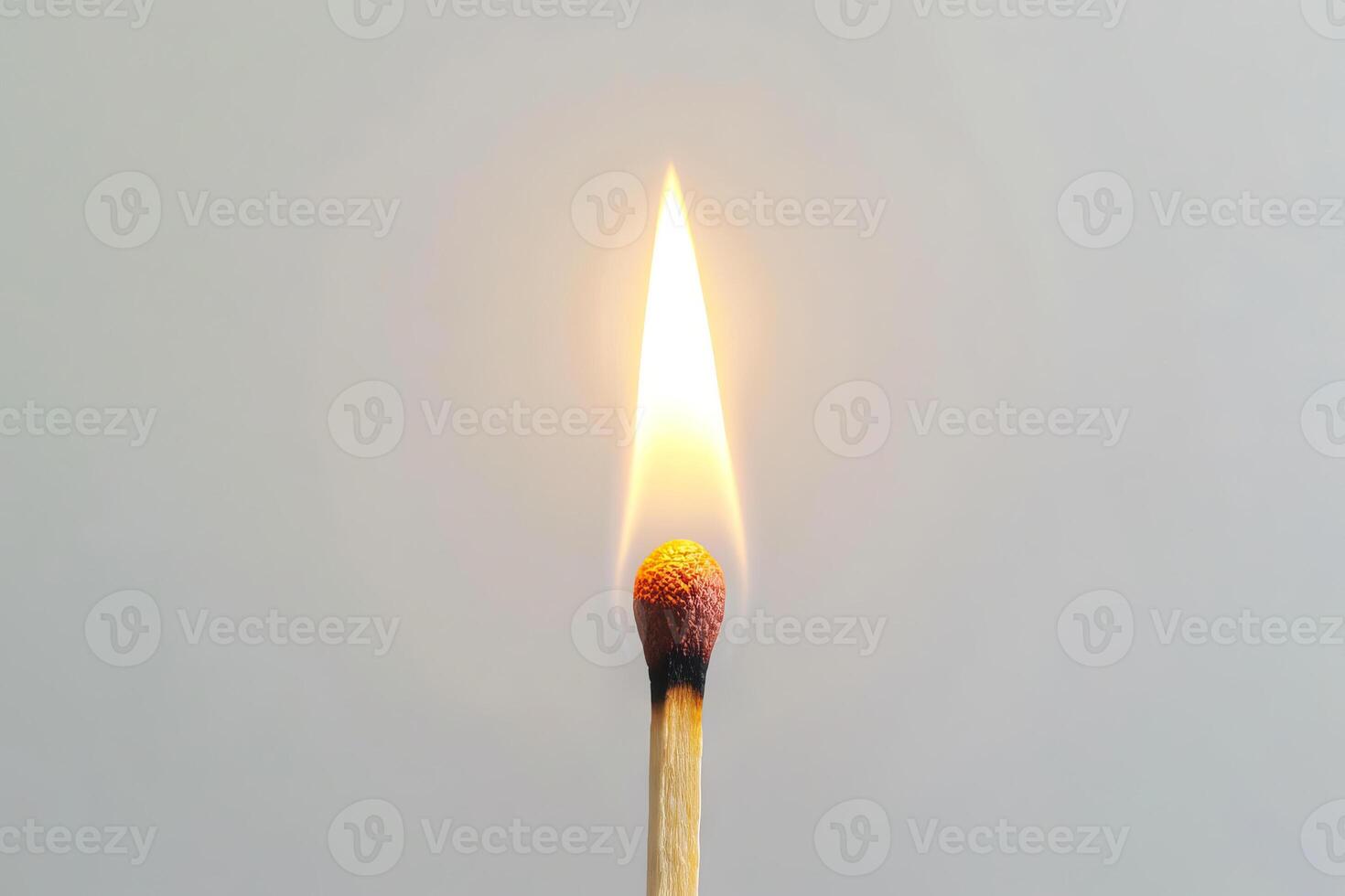 Single burning matchstick against a clean white background. Concept of ignition, heat, energy, simplicity, and minimalism. Copy space photo