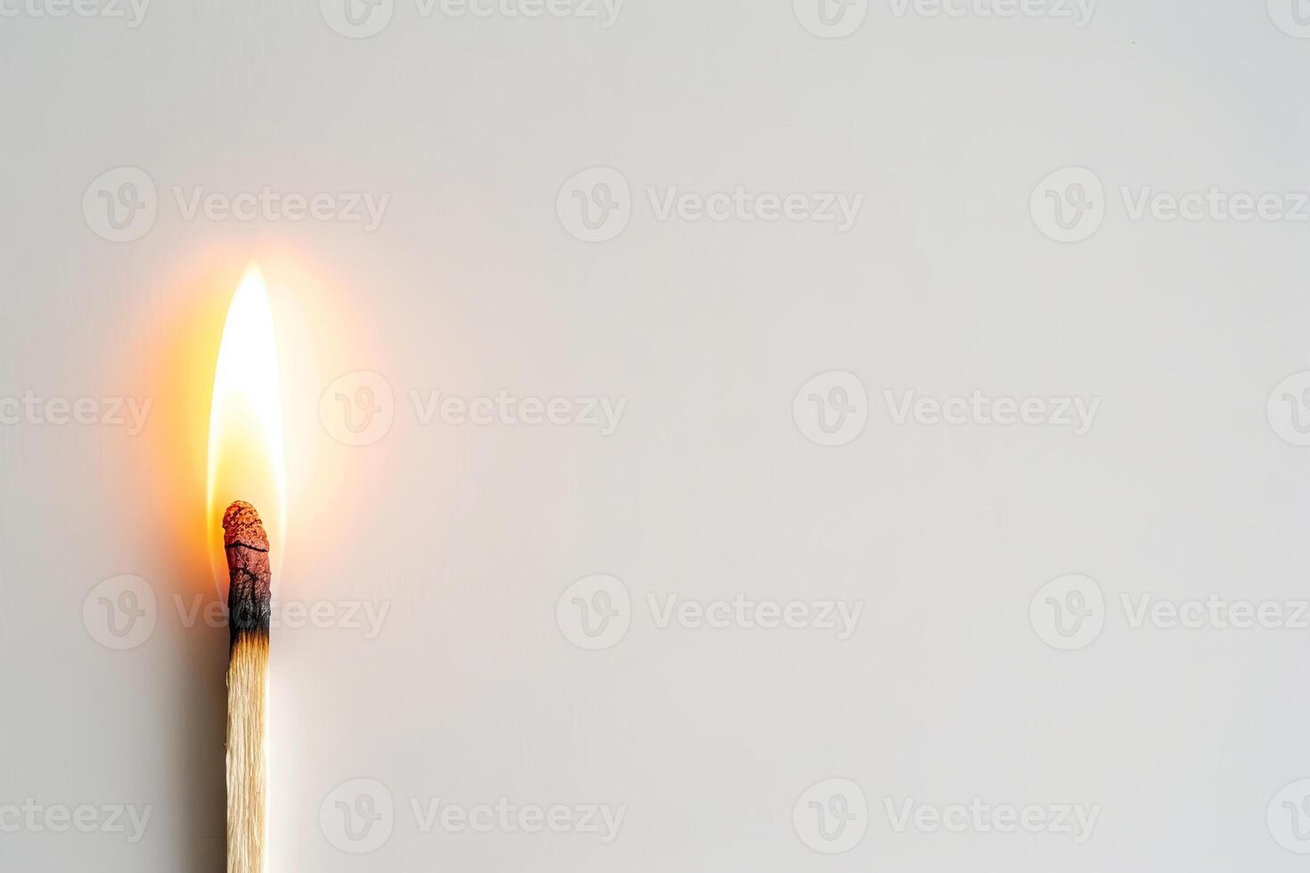 Close-up of a burning matchstick with a flame against a clean white background. Concept of fire, ignition, light, and heat. Copy space photo