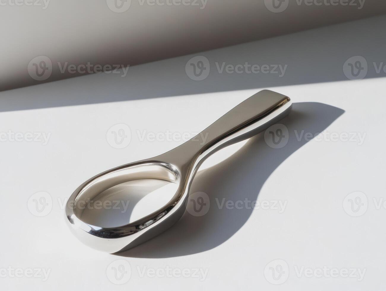 a silver spoon sitting on a white surface photo