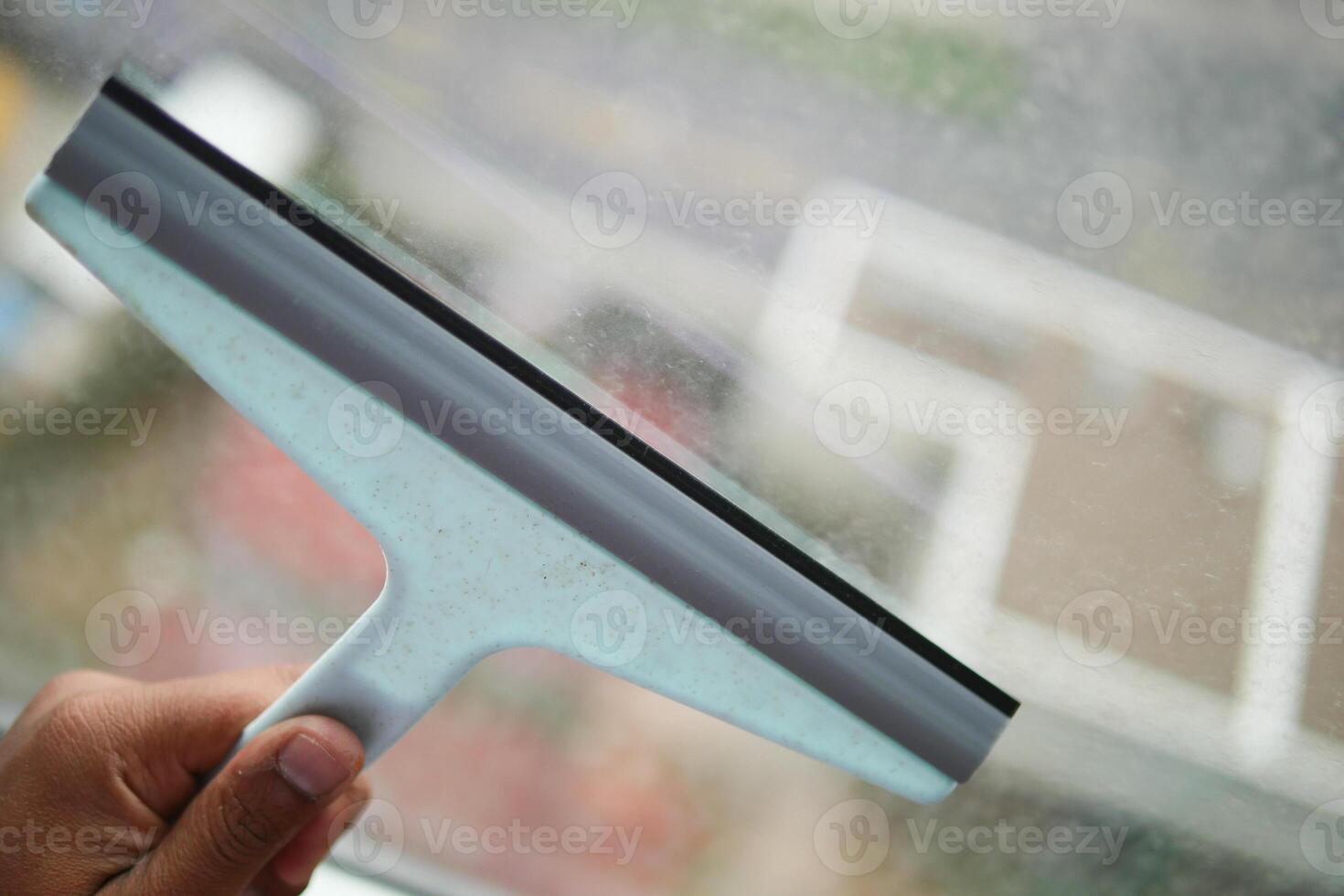 Cleaning windows with a squeegee. photo