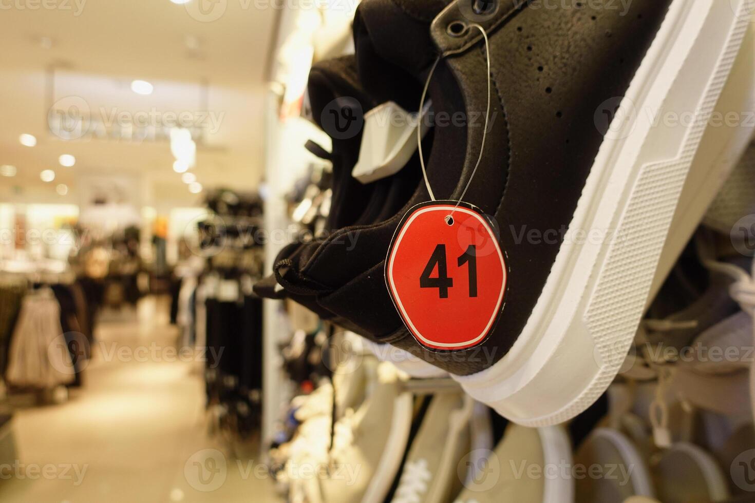 A closeup view of stylish black sneakers showcasing their size tag within a retail store setting photo