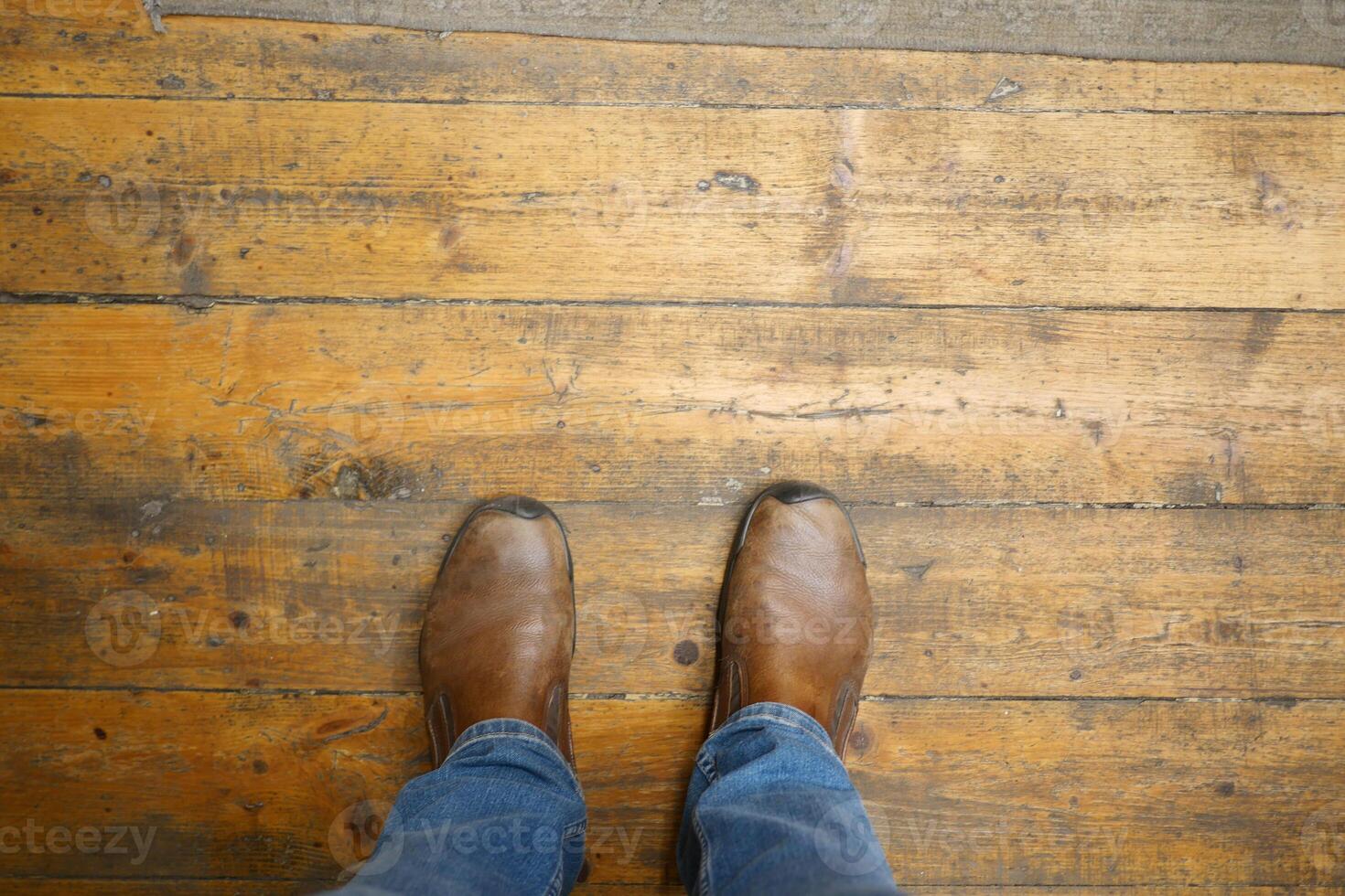 Stylish Casual Brown Boots Resting on a Rustic Wooden Floor with Natural Warmth and Texture photo