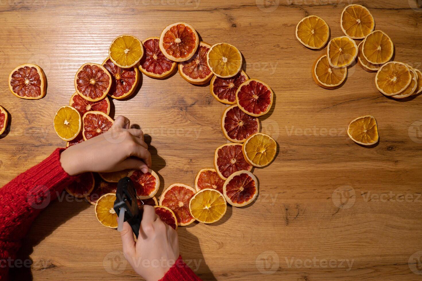 DIY process of woman making Christmas arrangement with dried oranges and grapefruits. Series of handmade craft instruction. Zero waste eco-friendly winter holiday decoration. New year photo