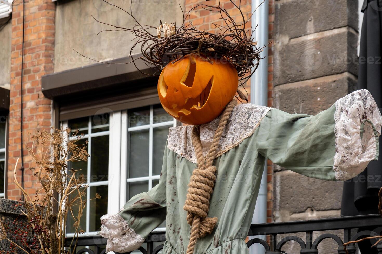 Halloween horror scarecrow decorated outdoor cafe or restaurant terrace in America or Europe with pumpkins traditional attributes of Halloween. Frontyard decoration for party. photo