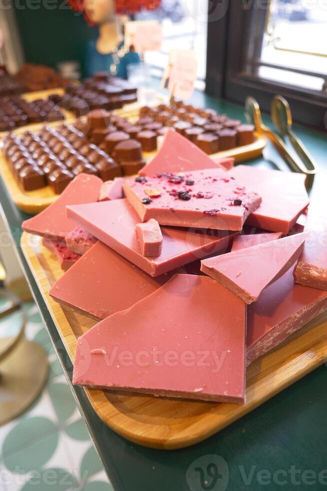 Wooden tray with magenta chocolate on a table at the event photo