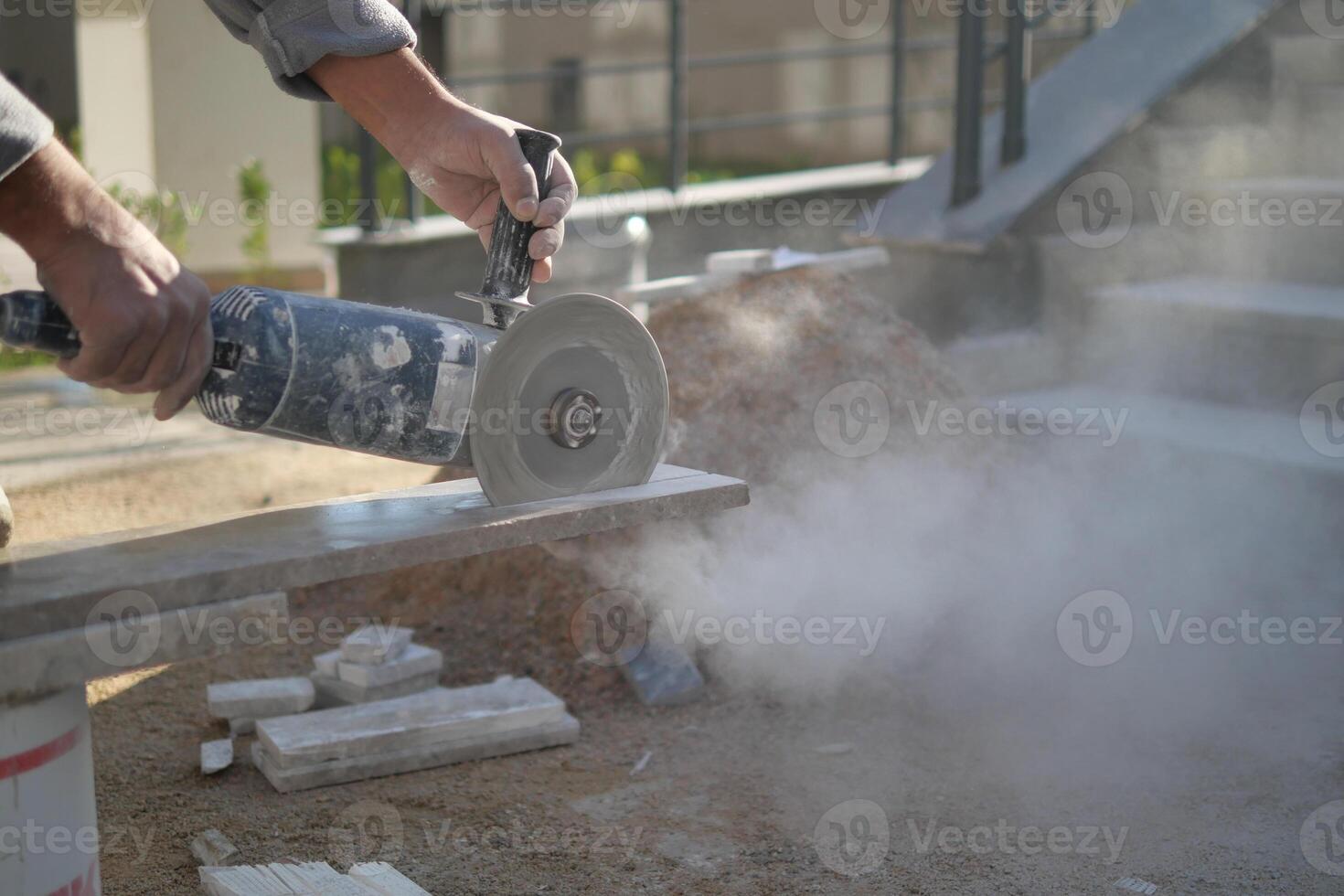Concrete cutting is currently being conducted with a power tool on a busy construction site photo