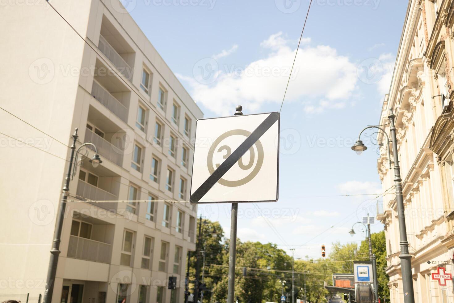 Road signs indicating speed limit and priority road with trees in the background photo