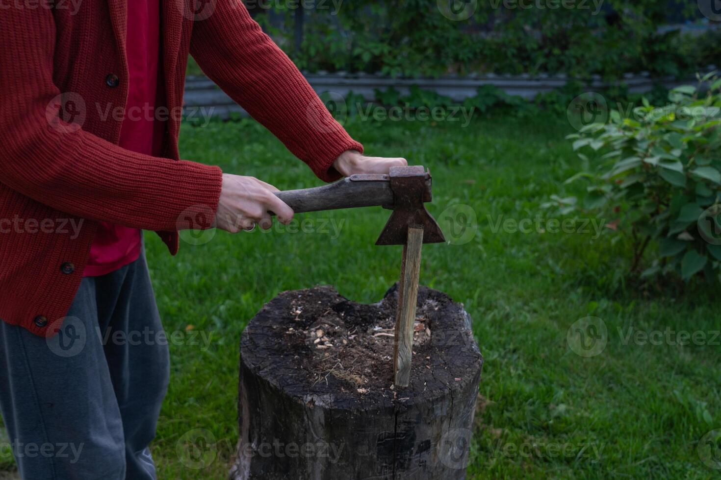 A man is chopping wood for a bonfir A man is chopping small firewood. Evening photo