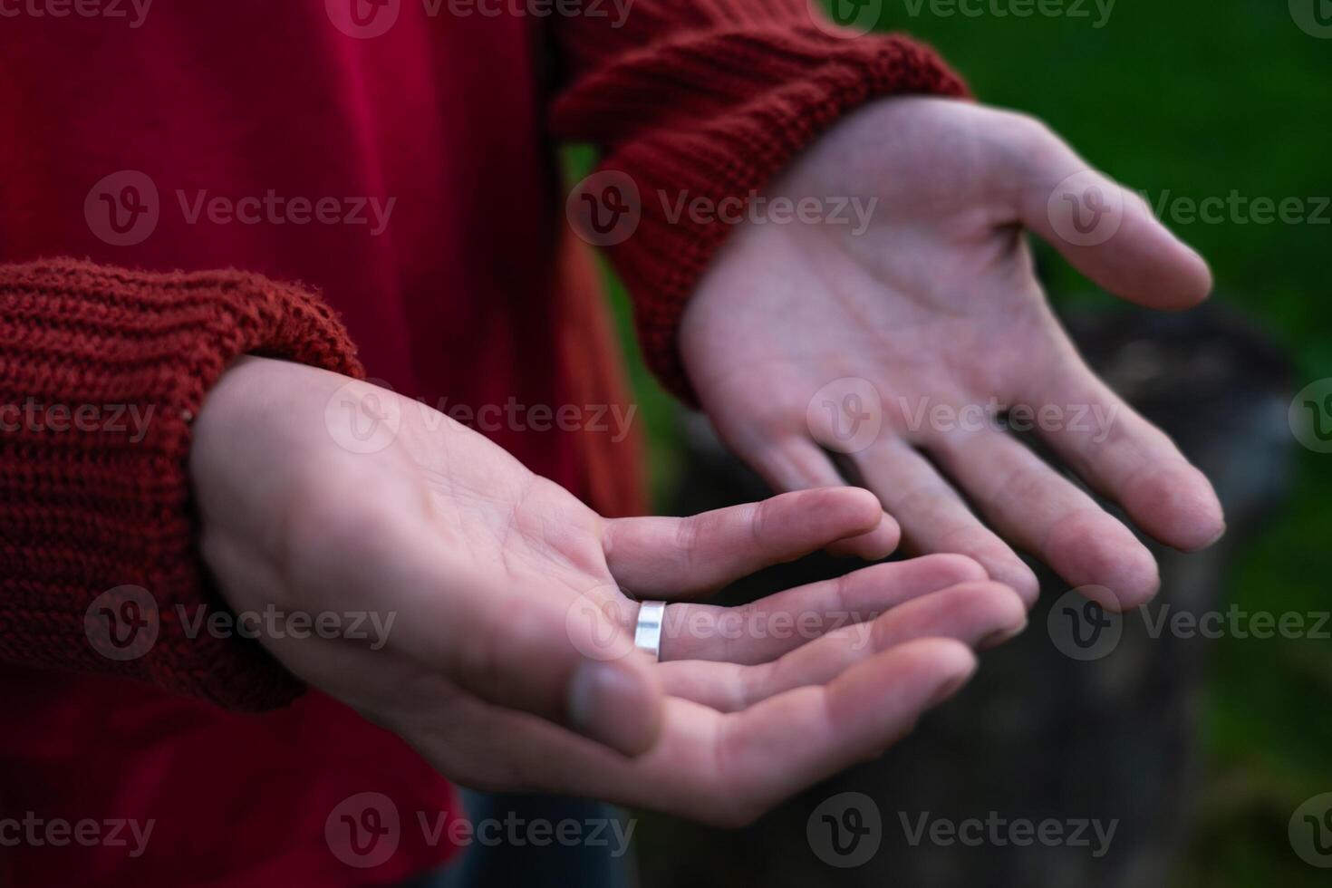 Empty palms of a man up close in a sweater. An engagement ring on her finger photo