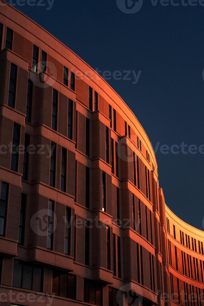 The business building in the form of a wave is illuminated late at night photo