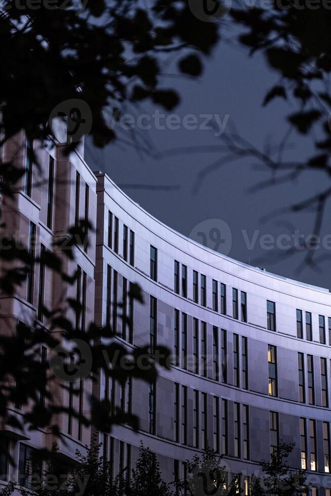 The business building in the form of a wave is illuminated late at night photo