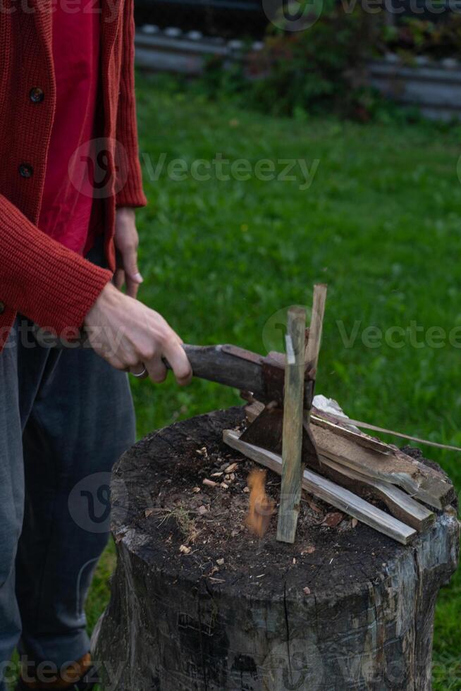 A man is chopping wood for a bonfir A man is chopping small firewood. Evening photo