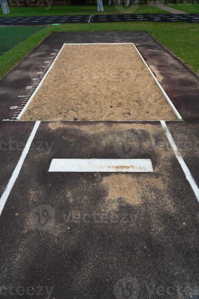 The jump pit at the school stadium. Long jump in the sand photo