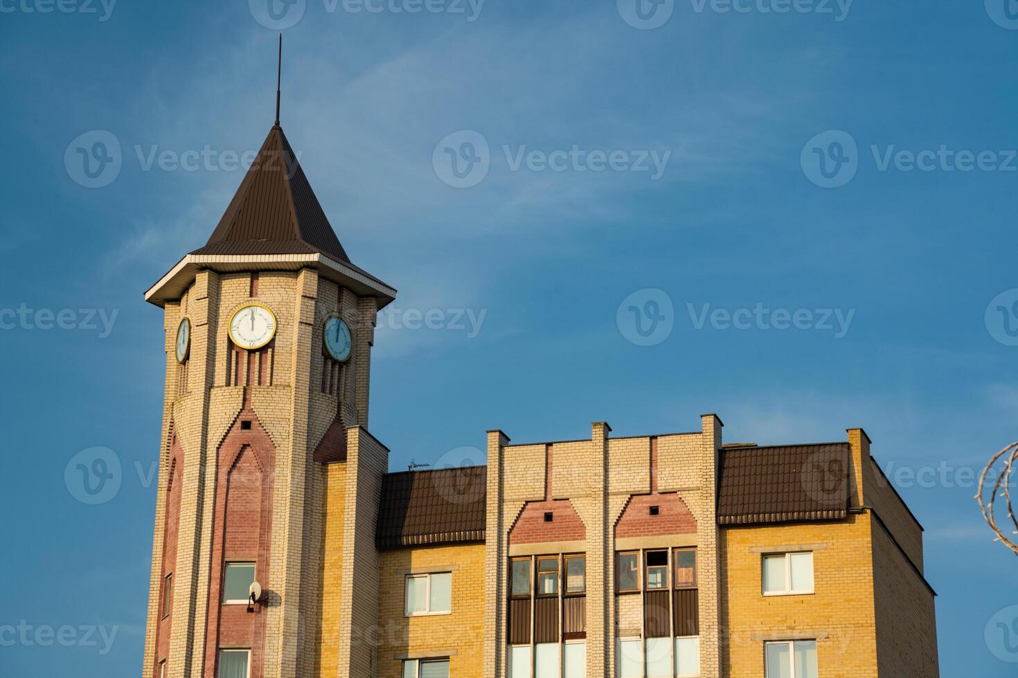 A tall, cone-shaped tower building in the city. Street clock on the tower photo
