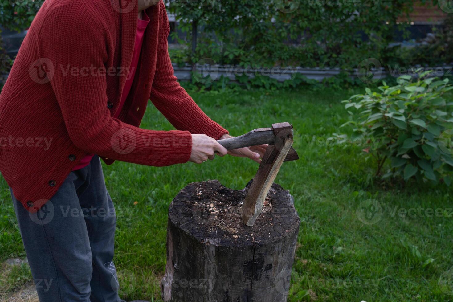 A man is chopping wood for a bonfir A man is chopping small firewood. Evening photo