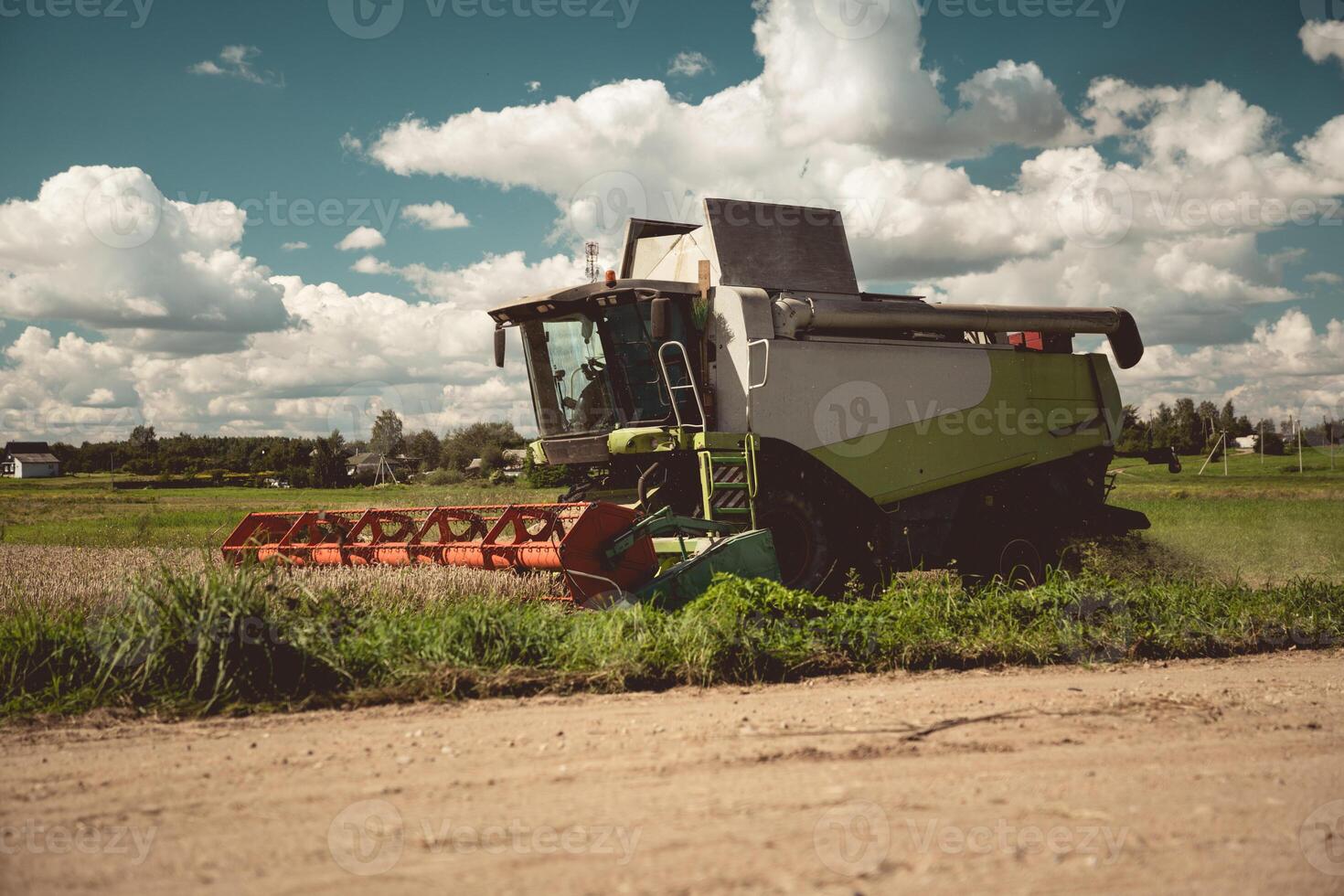 The harvester is working in the field. The combine harvester harvests wheat photo