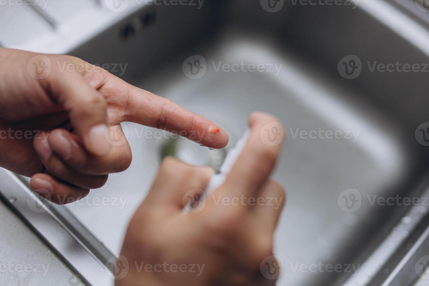 Man cut finger while cooking in kitchen, closeup photo