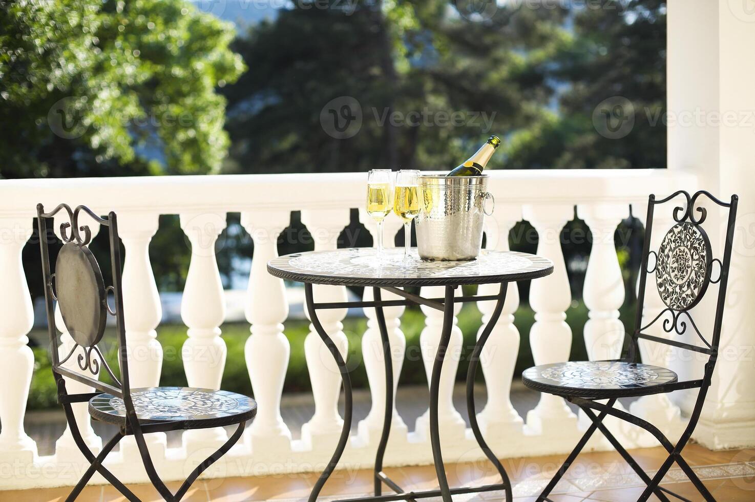 Champagne bottle and four flutes on the table photo