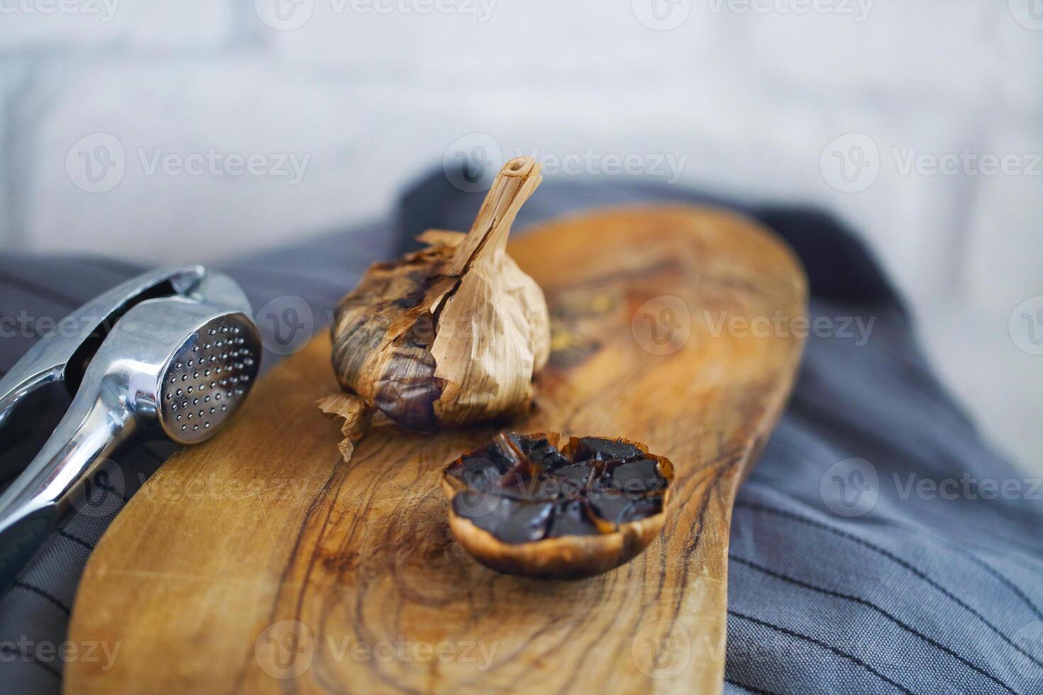 Black garlic bulbs and cloves on wooden background photo