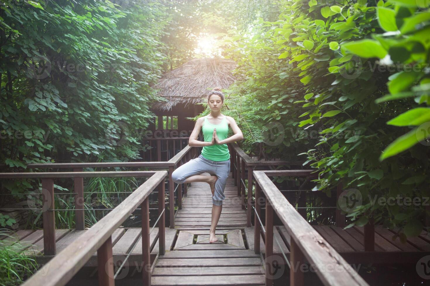 Young woman doing yoga asana in the evening photo