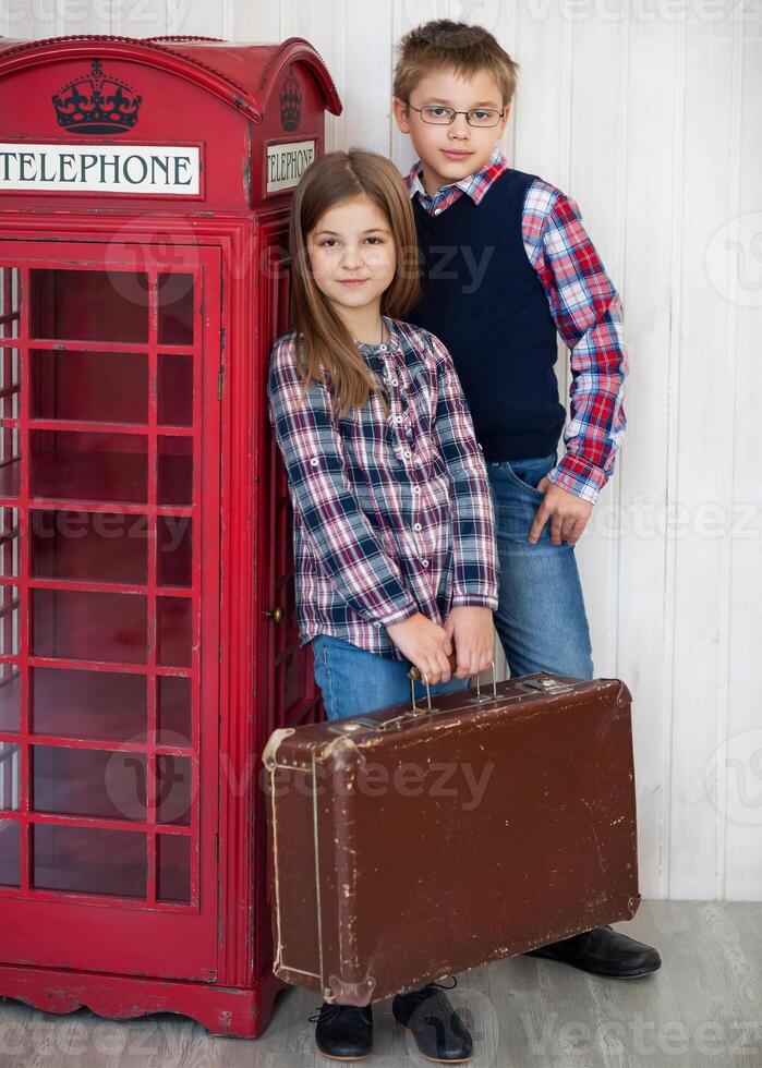 Portrait of a happy girl and a smiling boy with suit case photo