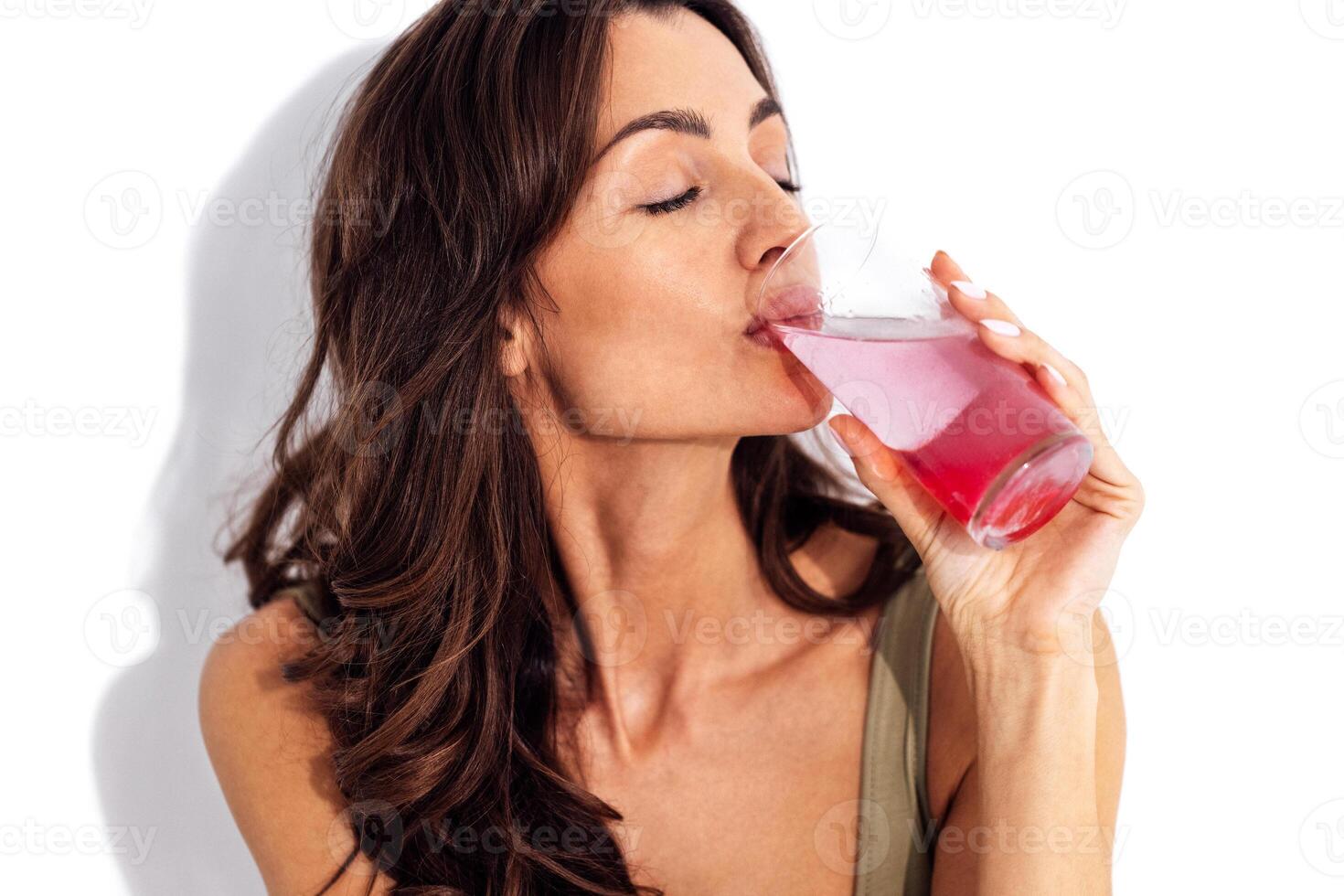 Young caucasian woman holding glass of water with collagen photo