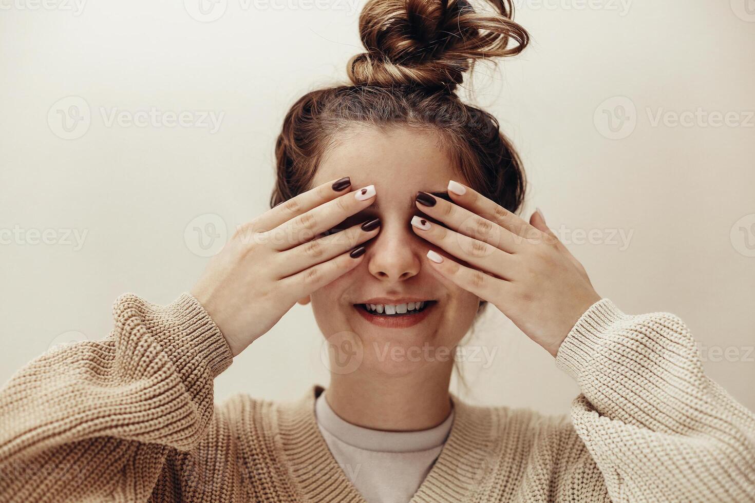 Close-up face of a woman with multicolor nails pink lips photo