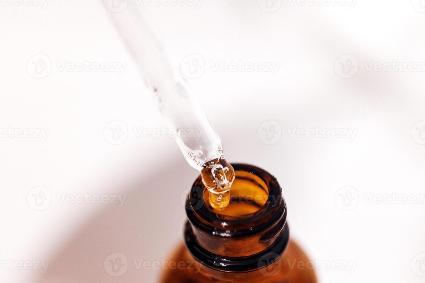 Close up of brown serum or oil glass with mock up on bottle on mirror background photo