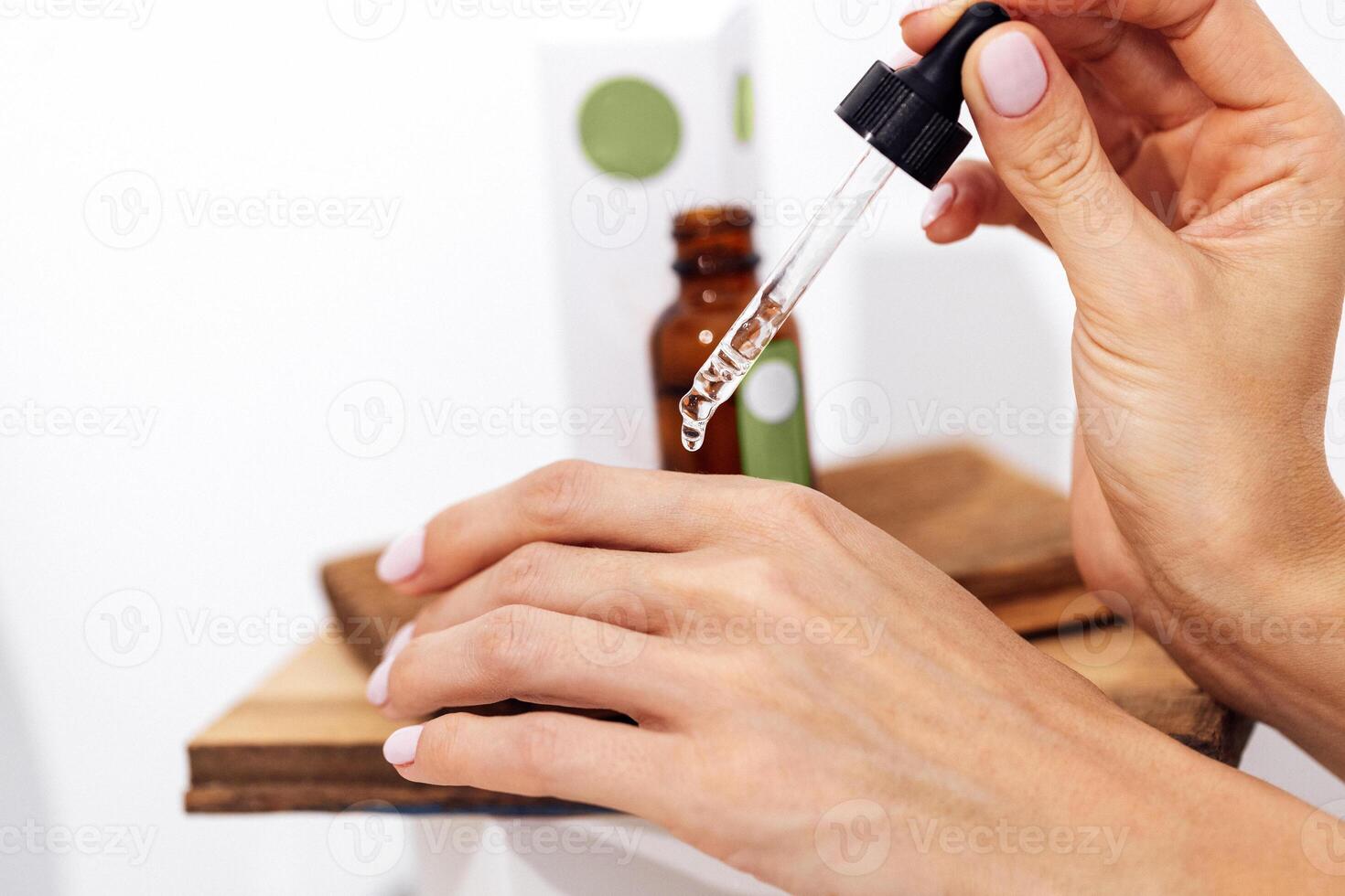 Transperent drop of essence, oil or gel drips from the pipette. photo