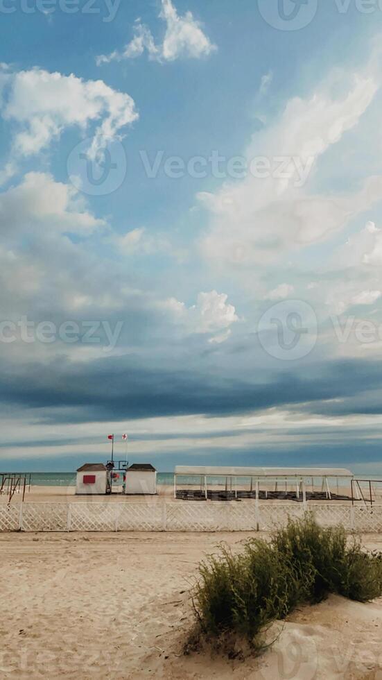 Fluffy storm clouds over empty sandy public beach photo