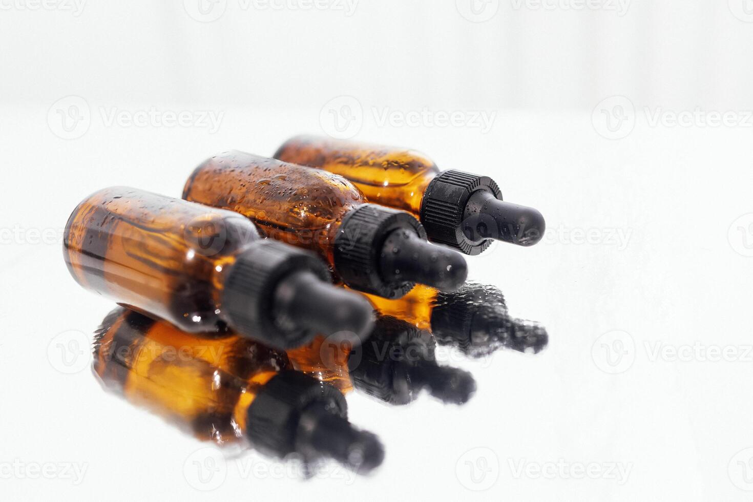 Group of bottles with drops on them and their reflection on a mirror surface photo