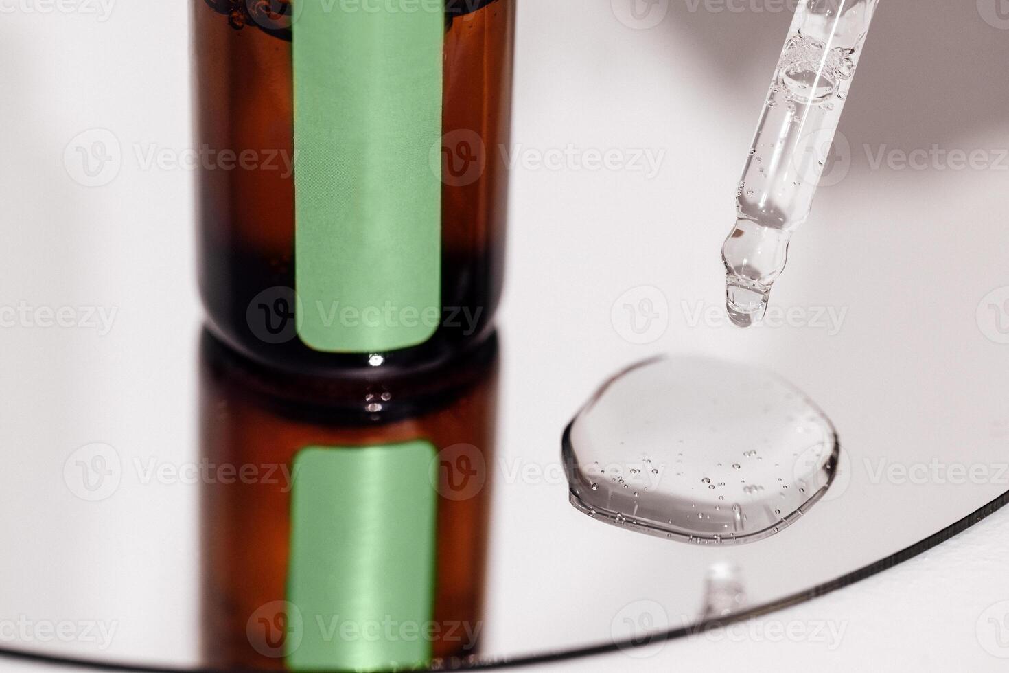 Close up of brown serum or oil glass with green stiker mock up on bottle on mirror background. Drops of liquid in a pipette. photo