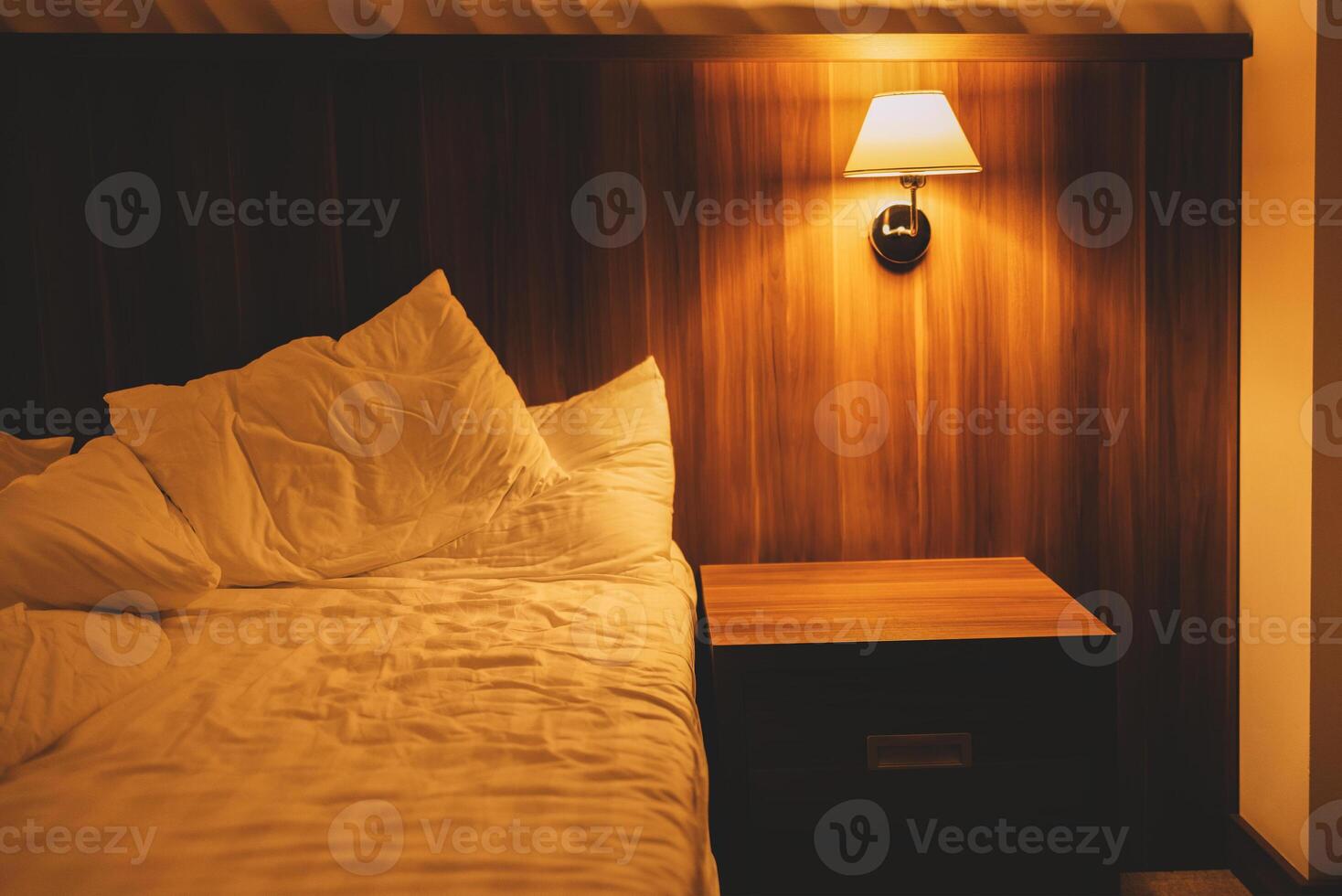 Empty bed with light linens, pillows and duvet. photo
