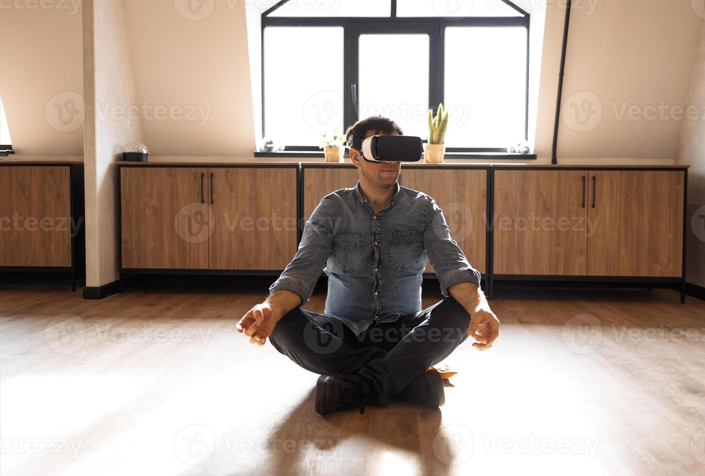 Portrait of a Stylish caucasian Man Using Virtual Reality Headset sitting on the floor at Home photo